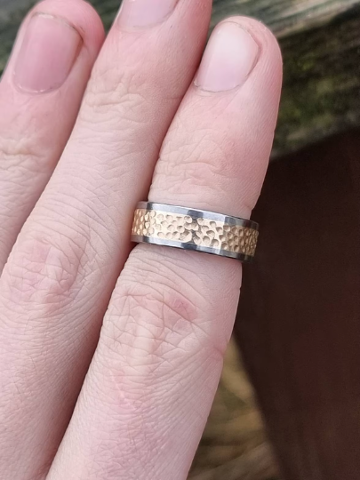 titanium and gold mens wedding ring on finger